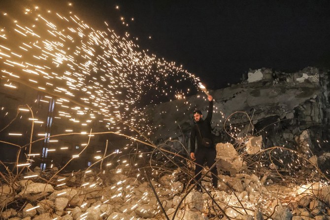 1年最後の夜、日没後のガザ市で自家製の線香花火を振り回す男性。(AFP)