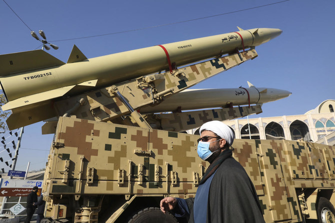 2022年1月7日、イランのテヘランにおいて保有ミサイルの威力を誇示するためイマーム・ホメイニ・グランドモスクに設置されたミサイル「ゾルファガール」（上）ならびに「デズフール」の前を通るイスラム聖職者。（AP）