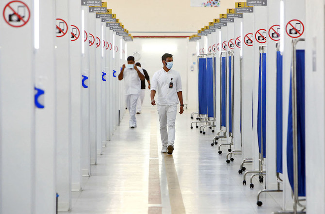 COVID-19ワクチン接種センターを歩くクウェートの医療従事者。2021年10月25日、クウェート市で。（AFP）