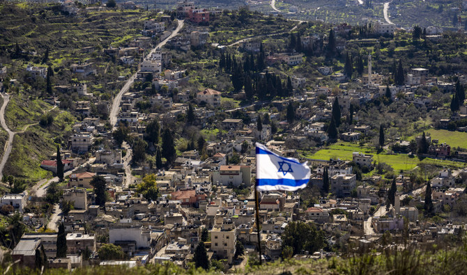 2022年1月17日（月）、イスラエル国旗が掲げられたユダヤ人のヨルダン川西岸入植拠点ホメッシュから見下ろす、パレスチナ人が住むブルカ村。（AP）