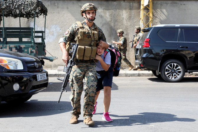 砲撃が始まったベイルートで、女子生徒を両親の元に連れていくレバノン軍の兵士、2021年10月14日。 （写真：ロイター）