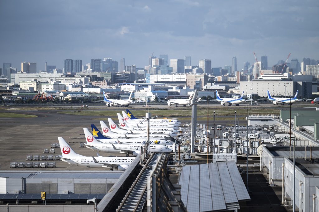 2021年11月8日、東京の羽田空港で、日本航空会社(JAL)、スカイマーク航空会社、全日本空輸(全日空)の飛行機が見られる。(AFP)
