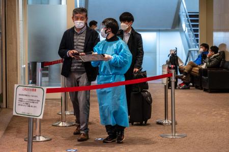 2022年1月25日、東京の羽田国際空港にあるPCRテストセンターの外で、Covid-19コロナウイルス検査に人々が並んでいる。（AFP）