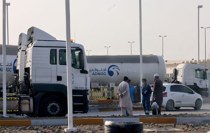 アブダビ国営石油会社(ADNOC)の石油貯蔵施設の外に立つ男たち、2022年1月17日。ADNOCの施設を狙ったとされる17日のドローン攻撃で、3名が死亡した。(AFP)