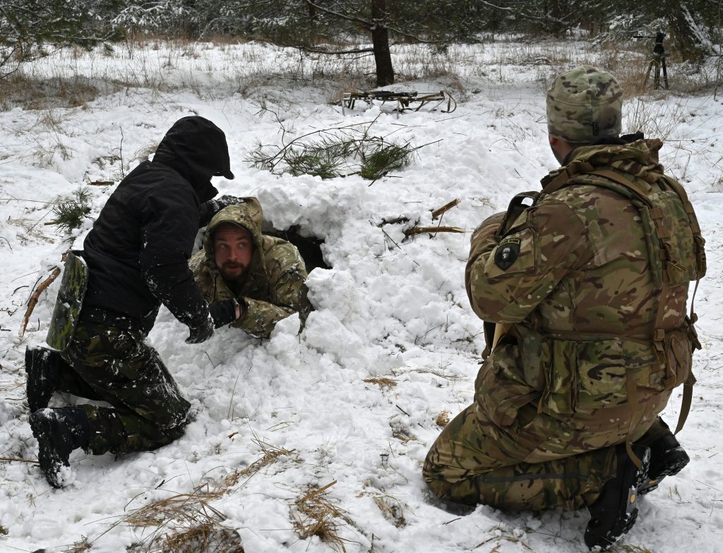 2022年1月30日、キエフ郊外の森林で、サバイバル技術の速修講座の一環として深く積もった雪からシェルターを造る方法を学ぶウクライナ市民たち。（AFP）