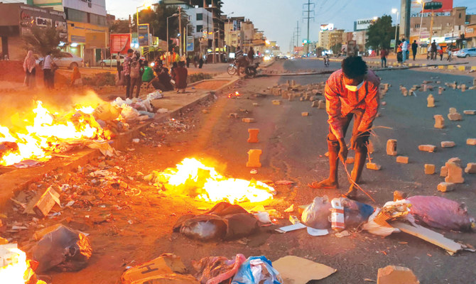 軍政に対する市民的不服従運動の一環として、ハルツームでレンガと火のバリケードを設置するデモ参加者たち。（AFP）