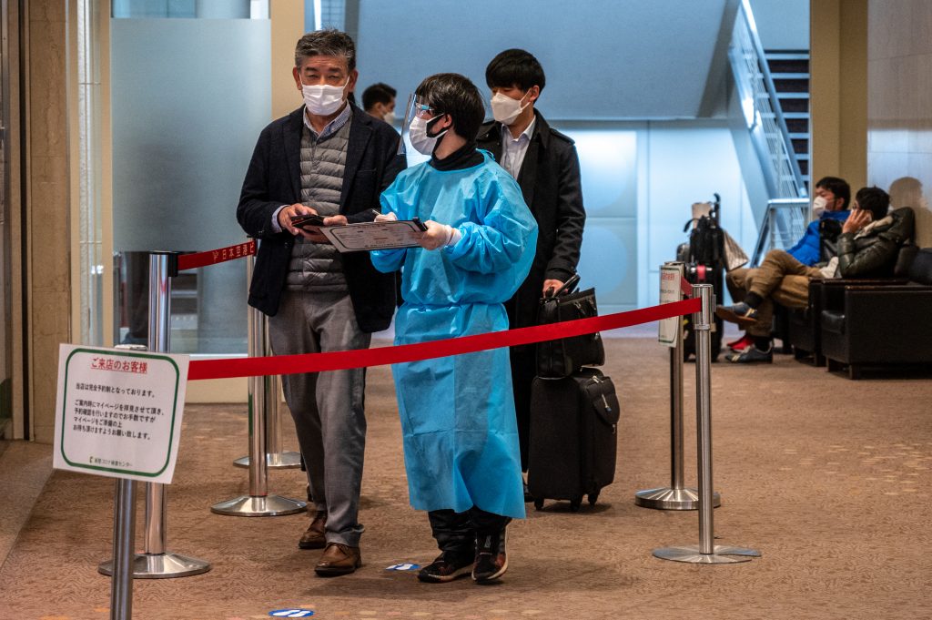  新型コロナのPCR検査を受けるため検査場の外に並ぶ人々。2022年1月25日、東京・羽田国際空港にて撮影。（AFP）