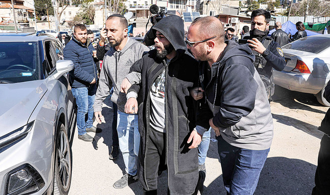 東エルサレムのシェイク・ジャラー地区で13日に起こった衝突の後、パレスチナ人男性を拘束するイスラエル治安部隊。（AFP）