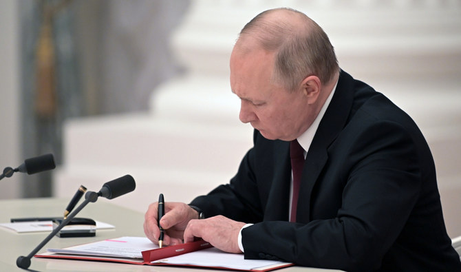 2022年2月21日月曜日。ロシア・モスクワのクレムリンで、ウクライナ東部の分離独立派地域の独立を認める文書に署名する、ロシアのウラジーミル・プーチン大統領。（AP）
