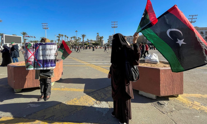 政治的な横断幕やリビアの旗を掲げるデモ参加者たち。リビア、トリポリの殉教者広場で。（ロイター／File）