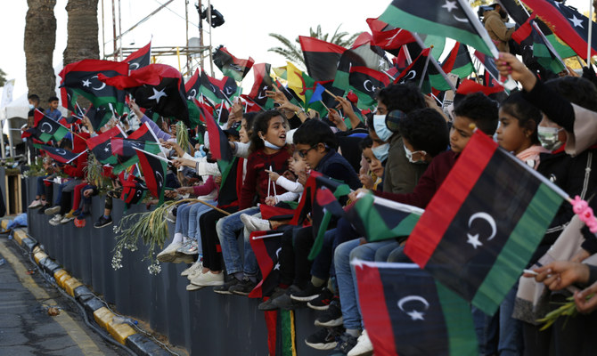 トリポリの殉教者広場で2月革命記念日を祝うリビアの人々。リビアは、対立する2人の首相を抱えることになった状況でこの記念日を迎えている。(AP)