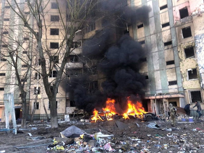 2022年3月20日に公開されたこの配布資料の写真では、ウクライナのキエフで、ロシアからウクライナへの攻撃が続く中、空爆で損傷した住宅ビルの外で燃え盛る車両から煙が上がっている。（ロイター）