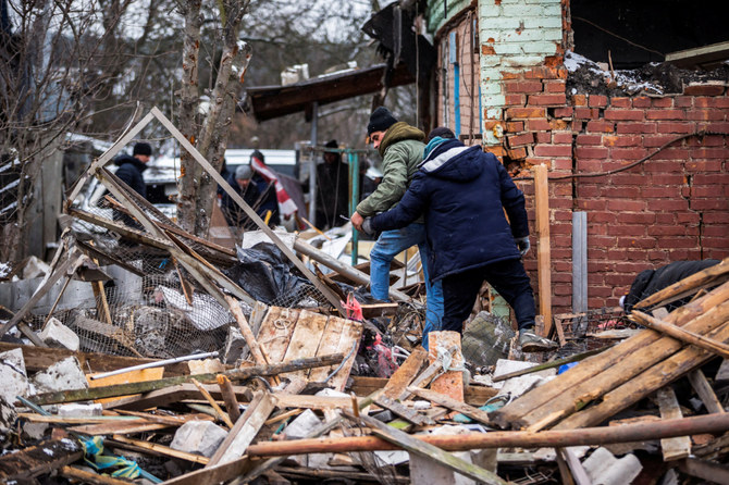 ロシアのウクライナ侵攻が続く中、砲撃で破壊された住宅ビルの瓦礫の中を歩く地元住民。（ウクライナ・ジトーミルにて、2022年3月2日）（ロイター）