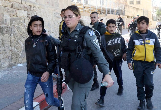 イスラム教徒の聖地であるイブラヒム・モスク付近からパレスチナ人の子供たちを移動させるイスラエル国境警備隊（2022年2月28日、ヘブロン）。（AFP通信）