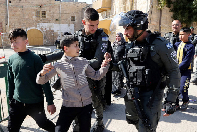 イスラム教徒の聖地であるイブラヒム・モスク付近からパレスチナ人の子供たちを移動させるイスラエル国境警備隊（2022年2月28日、ヘブロン）。（AFP通信）