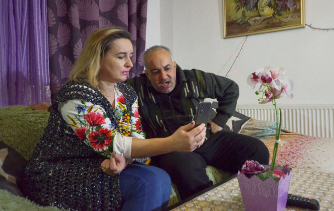2022年2月26日、ヨルダンのアンマンで、ウクライナにいるヨルダン人学生ダイアナ・アル・アワムレさんの両親、ウェッサムさんとタチアナさんが、携帯電話で彼女と話している。（ロイター）