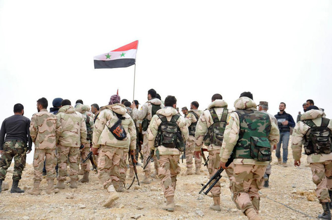 2016年3月27日、シリアのパルミラで、シリア国旗の周りに集まるシリア兵たち。(APフォト)