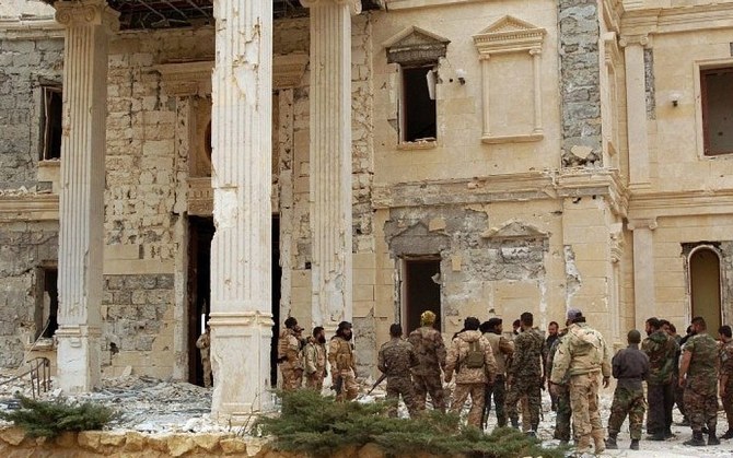 2016年3月24日、シリアの古代都市パルミラのカタール王家が所有する邸宅の横に立つシリア軍部隊。（AFP通信）