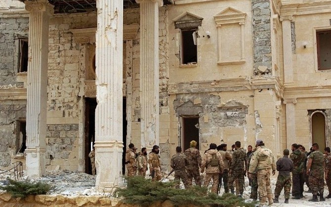 2016年3月24日、シリアの古代都市パルミラのカタール王家が所有する邸宅の横に立つシリア軍部隊。(AFP通信)