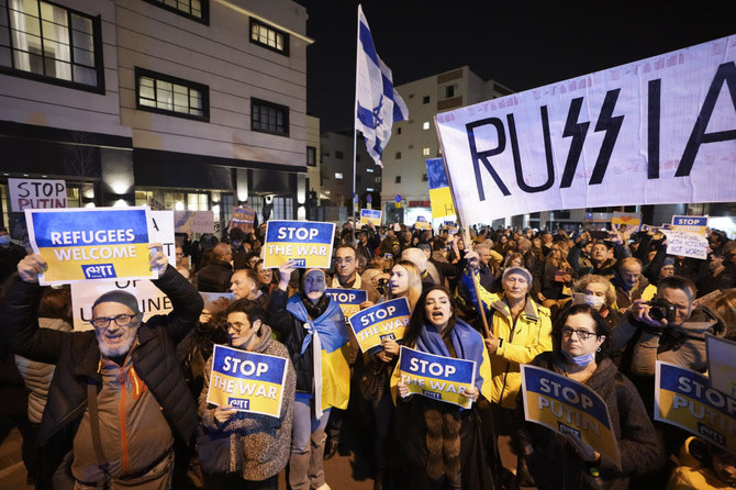 土曜日、テルアビブのロシア大使館の前で、ロシアのウクライナ侵攻に反対する抗議行動でプラカードを掲げる人々。(AP)