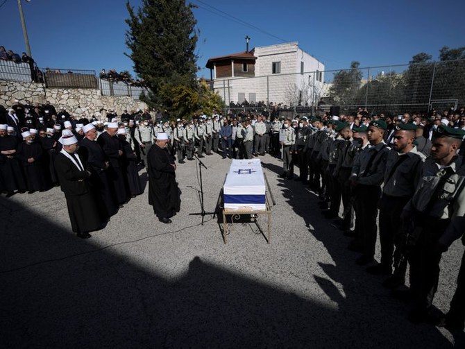 2022年3月28日月曜日、イスラエル北部のキスラ・スメイ村で行われた葬儀で、ドルーズ派のイスラエル国境警察官イェゼン・ファラ氏19歳の旗で覆われた棺の周りに集まる弔問客たち。（AP通信）