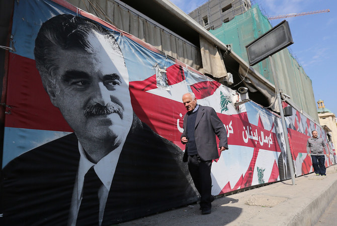 殺害されたラフィク・ハリーリ レバノン元首相の肖像画の前を通りすぎる男性。（ファイル写真：AFP）