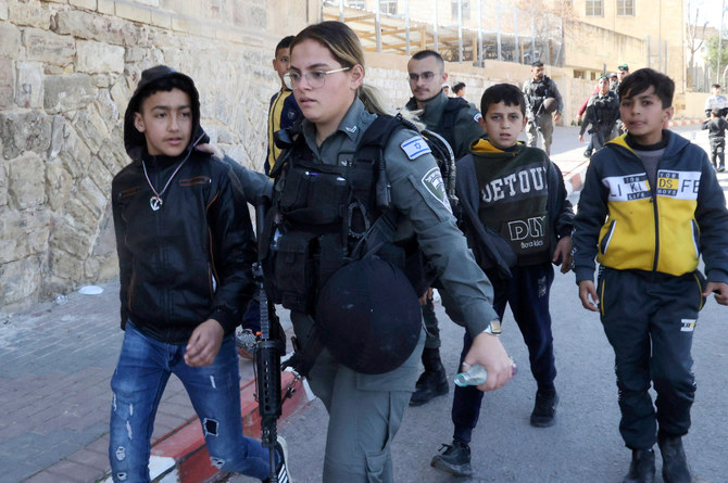 2022年2月28日、ヨルダン川西岸の分断都市ヘブロンにあるイブラヒミ・モスク付近で、イスラエルの国境警察がパレスチナの子どもたちを排除する。（AFP）
