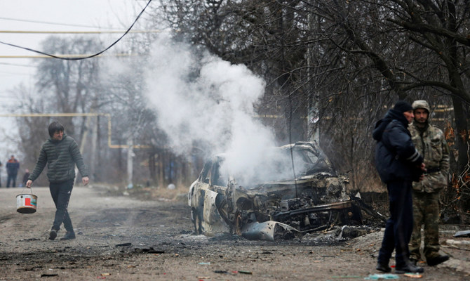 2022年2月28日、ウクライナの分離主義者が支配するドネツク市で、最近の砲撃の後、燃えた車から煙が上がっている。（ロイター）