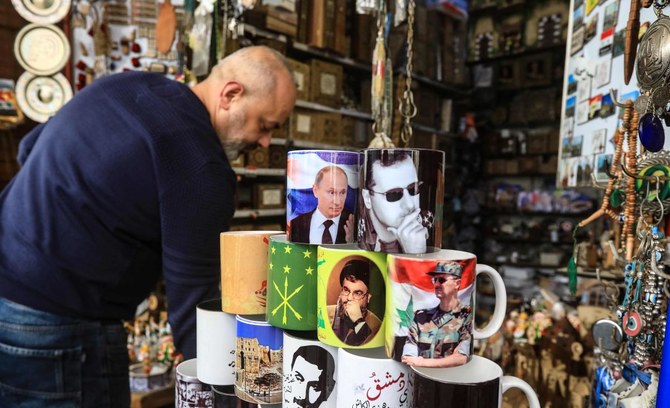 2022年2月27日、ダマスカス旧市街。シリアのアサド大統領、ロシアのプーチン大統領、レバノンのシーア派組織、ヒズボラの指導者ハッサン・ナスラッラー氏の画像がプリントされたマグカップを並べる土産物店の店主。（SANA/AFP）