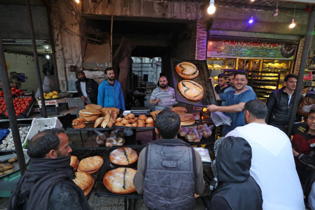 2020年4月24日、シリア北西部の都市イドリブで、パン屋の前に列を作る人々。(オマー・ハジ・カドウアー/AFP)