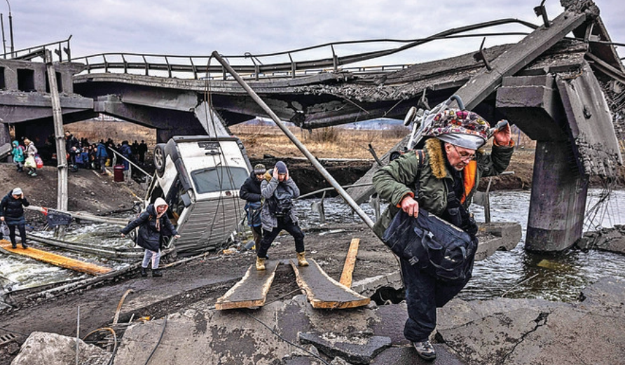 7日、民間人のための安全な避難ルートが求められる中、キエフ北西の都市イルピンから退避する途中に破壊された橋を渡るウクライナ難民たち。（AFP通信）