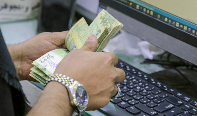 イエメンのアデンの地元通貨取引所でイエメン・リヤル紙幣を数えるレジ係。（ロイター　資料写真）