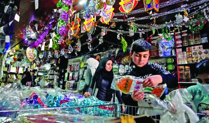 レバノン、ベイルートの商店でラマダンのための装飾品を買い求める人々。レストランでのイフタールの食事は高額になるため、彼らは自宅で断食明けの食事をすることを選択している。（AP）