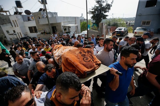 イスラエル軍に殺害されたパレスチナ人女性ガディール・サバティンさんの葬儀で遺体を運ぶ人々。2022年4月10日、イスラエル占領下のヨルダン川西岸地区にあるフサンにて。（ロイター）