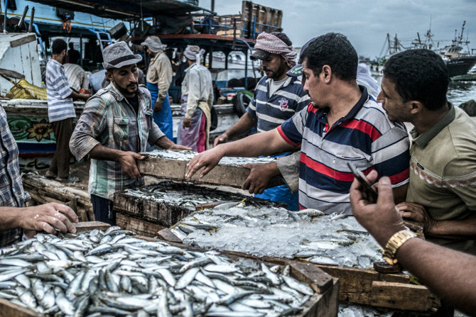 ナイル川デルタ地帯のダミエッタ支流沿いにあるエジプトの町、エズベト・アル・ボルグの桟橋で、獲れたての魚を売り歩く労働者。（AFP/ファイル）