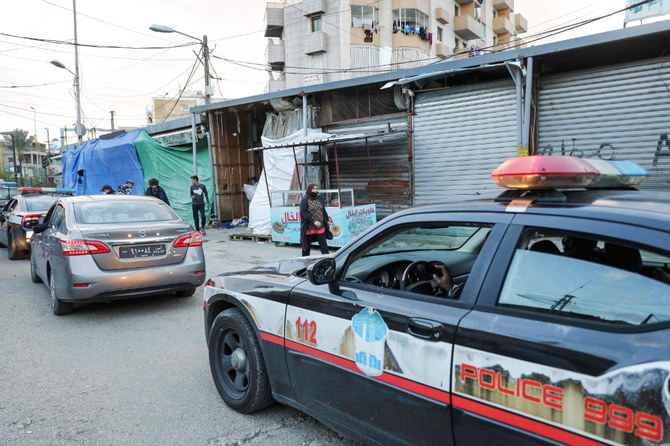 レバノンの首都ベイルートの南郊に位置するスーク・サブラで、レバノン警察のパトカーの脇を通り抜ける人々。（資料写真AFP）