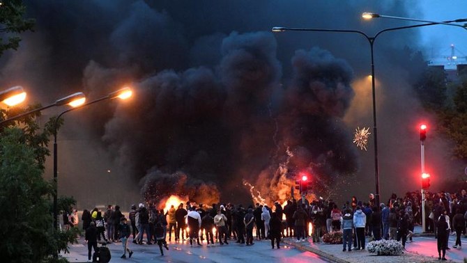 2020年8月28日、スウェーデン・マルメのローゼンゴード地区で発生した暴動の際に、燃えているタイヤ、パレット、花火からもうもうと立ち上る煙。（ロイター）