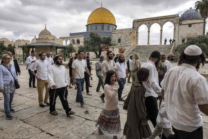 エルサレムのアル・アクサモスク敷地内で水曜、イスラム教徒には「ハラム・アル・シャリフ」として知られる「神殿の丘」を訪れ、「岩のドーム」の前を通り過ぎるユダヤ人男女信者の一群。（AFP）