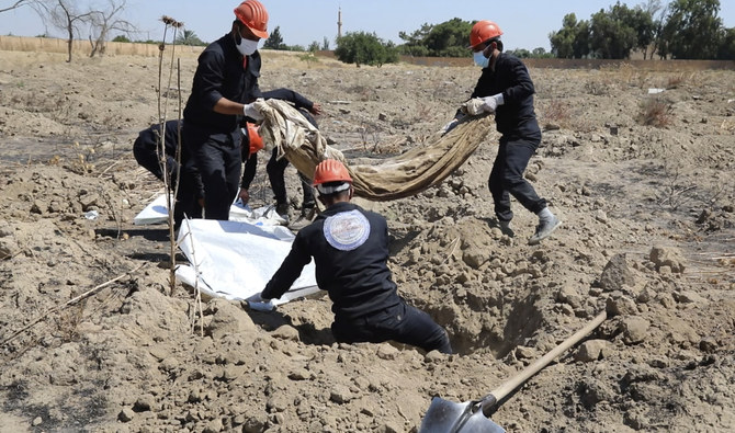 2019年7月14日、シリアのラッカで、民間人やダーイシュ過激派の遺体を埋葬したとみられる集団墓地の現場。ラッカ市民評議会のシリア人労働者が人骨を掘っている様子を撮影した動画のスクリーンショット。（AP/ファイル）