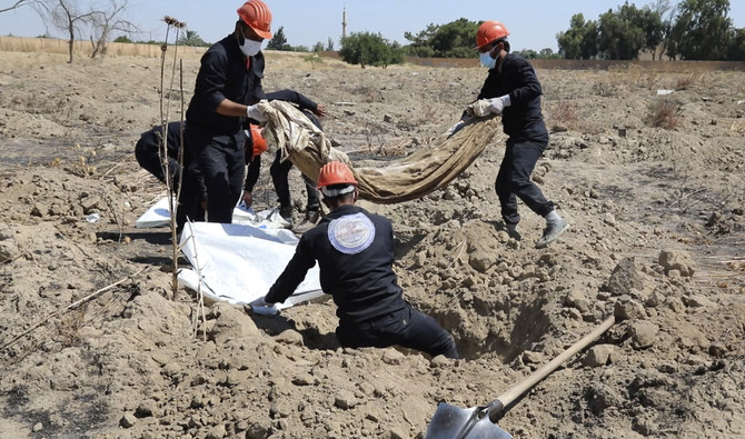 2019年7月14日、シリアのラッカで、民間人やダーイシュ過激派の遺体を埋葬したとみられる集団墓地の現場。ラッカ市民評議会のシリア人労働者が人骨を掘っている様子を撮影した動画のスクリーンショット。(AP/ファイル)