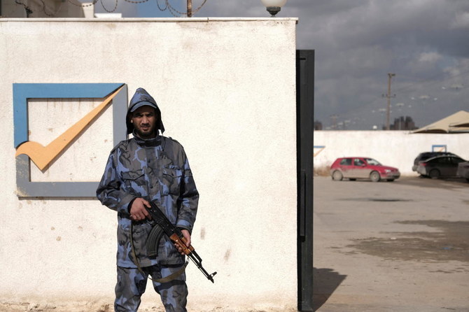リビアのベンガジで高等国民選挙委員会の建物の正面側を警備する警備員。（ロイター）