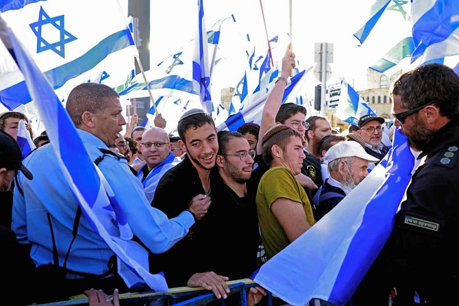 2022年4月20日、「旗の行進」中、ツァハル広場に向かって国旗を掲げて行進するイスラエルのデモ隊がイスラエル警察ともみ合いになった。(AFP)