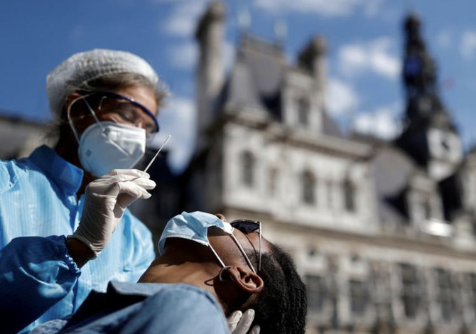 フランス・パリ市役所前に設置されたコロナウイルス感染症（COVID-19）の検査場で、防護服とマスクを着用し、鼻腔スワブ検査の準備をする医療従事者。（ロイター／ファイル）