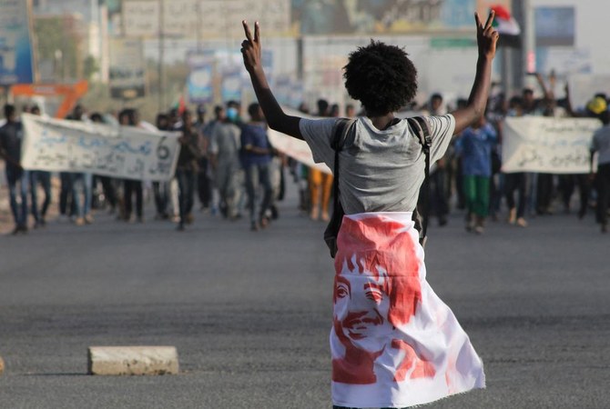 6日、首都ハルツームで、過去の民衆蜂起の記念日に、軍事支配に反対する集会に参加するスーダンのデモ参加者たち。(AFP通信)