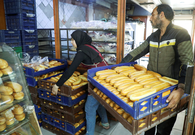 2022年3月29日、レバノン・ベイルートのパン屋でパンの箱を運ぶ従業員ら。（ロイター）