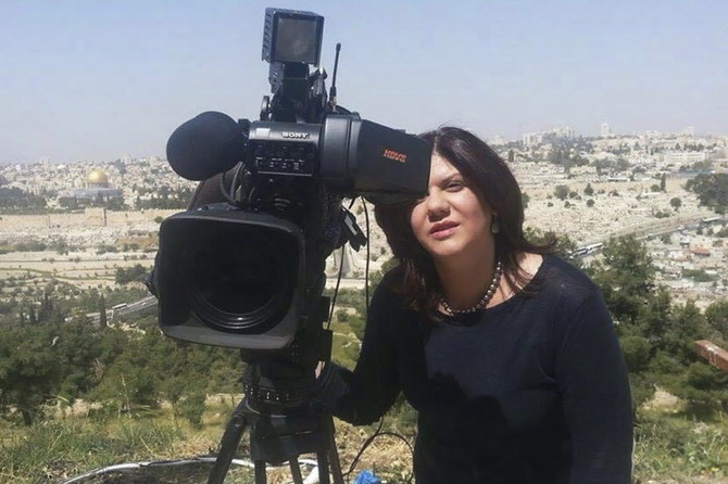 アルジャジーラ放送の提供による日付不明の写真。エルサレムのアル・アクサモスクにある「岩のドーム」が左側の背景に写り込む場所で、シリーン・アブアクラ記者がテレビカメラを覗いている。（AP）　
