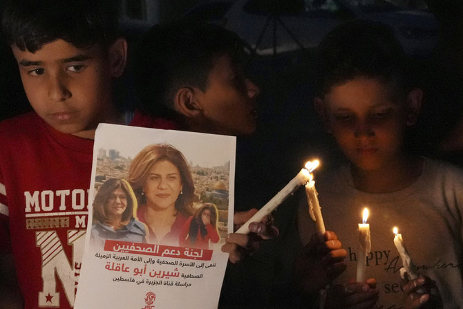 2022年5月11日、ガザ市で殺害されたアルジャジーラ記者シリーン・アブアクラ氏の写真とキャンドルを持つパレスチナの子供たち。（AP写真/アデル・ハナ）
