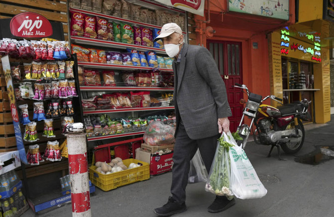 2022年5月11日（水）、イランのテヘランで、食料品店の前で買い物を運ぶ老人。(AP)