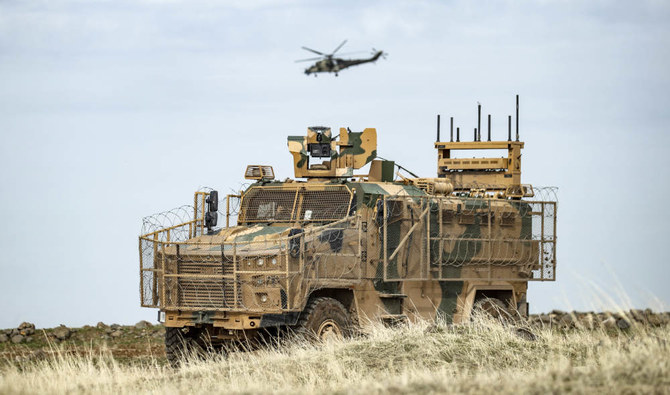 トルコ国境に近いシリア北東部ハサケ県で、トルコ軍車両の上空を飛ぶ攻撃ヘリコプター。(AFP/ファイル・写真)