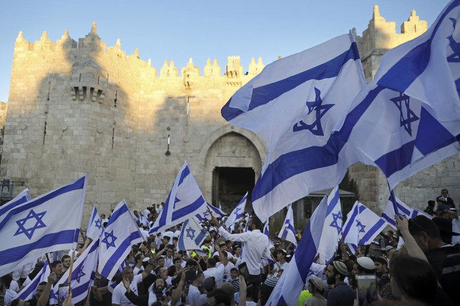 2021年6月、エルサレム旧市街外のダマスカス門横で行われた「国旗行進」で、イスラエル国旗を振るユダヤ人国家主義者ら。（APファイル／写真）